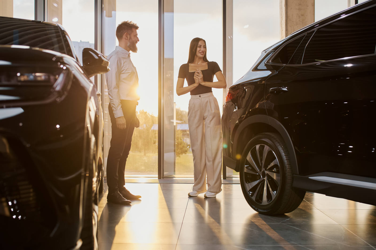 Beratungsgespräch zwischen Berater und Kundin im Autohaus